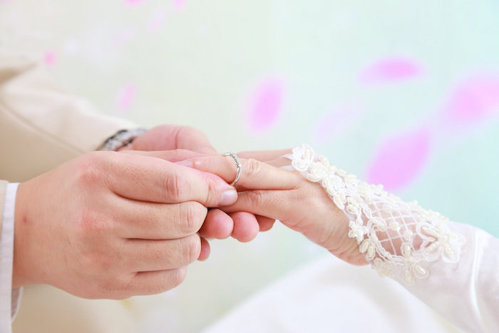 マッチングアプリで出会った50代の男女が婚約指輪をはめている様子